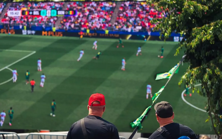 Spectateurs vus de dos dans la tribune d’un stade pendant un match